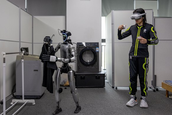 An IO-AI Tech staff member trains a humanoid robot to do laundry at the company’s headquarters in Shenzhen.
