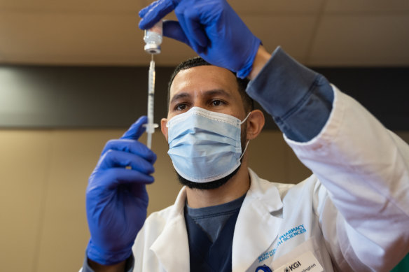 A pharmacy student prepares a dose of the Moderna vaccine at a mass vaccination site in California.