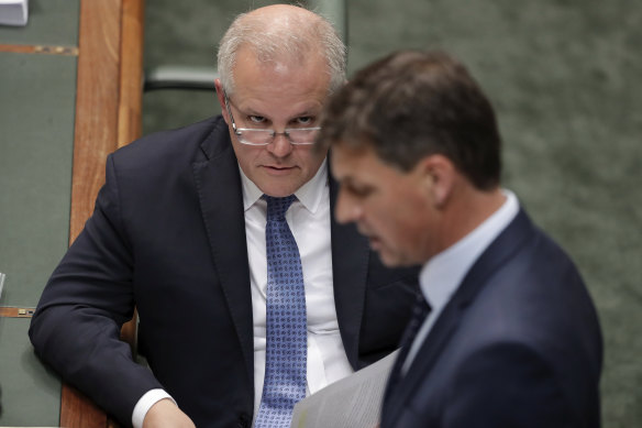 Prime Minister Scott Morrison listens as Minister for Energy and Emissions Reduction Angus Taylor responds to a question during Question Time at Parliament House in Canberra on Thursday .