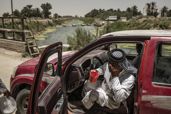 Adnan al-Sahlani tries to cool off in Shaat al Kabir, Iraq, near an illegal, generator-powered pumping station that he claims allows farmers to overdraw from the canal, leaving little for those further downstream.