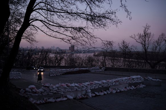 Barricades partially block a road at dusk in Kyiv.