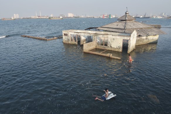 Children swim next to an abandoned mosque in Jakarta.