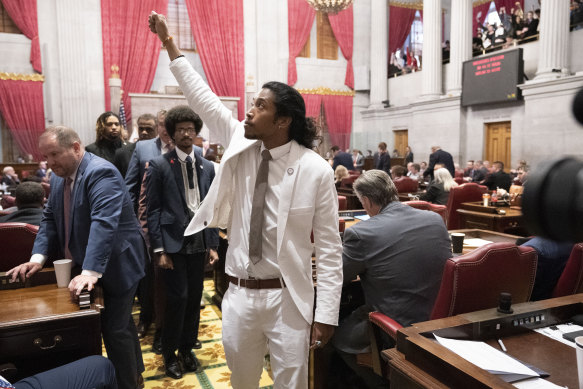 State Representative Justin Jones raises his fist on the floor of the House chamber as he walks to his desk to collect his belongings after being expelled from the legislature in Nashville, Tennessee.