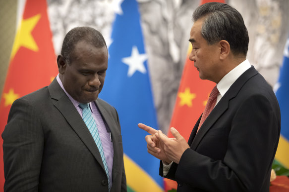 Solomon Islands Foreign Minister Jeremiah Manele, left, and Chinese Foreign Minister Wang Yi talk during a ceremony to mark the establishment of diplomatic relations between their two countries in 2019.