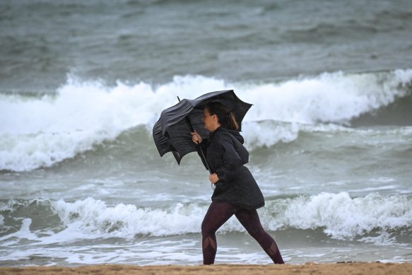 A woman battles through the wild weather in Port Melbourne on Wednesday morning.