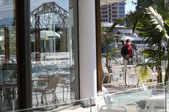 A Brisbane resident walks past a closed restaurant during the COVID lockdown in early August last year.