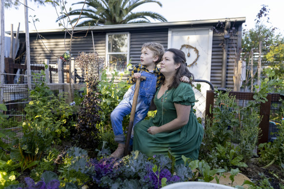 Samantha Kelly with her son William, 7, in the garden of their new home after they fled contaminated Williamtown. Kelly fears her son’s health issues could be linked to exposure to “forever chemicals” after he was born with high levels in his blood. 