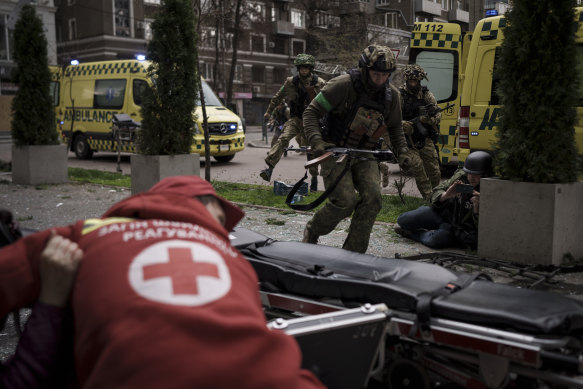 Ukrainian servicemen run for cover as explosions are heard during a Russian attack in Kharkiv on Sunday.