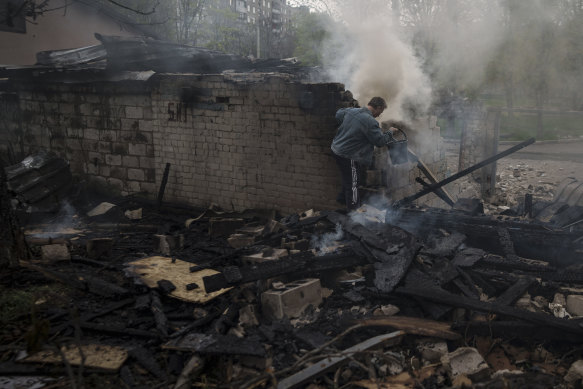 A man tries to extinguish a fire following a Russian bombardment at a residential neighborhood in Kharkiv.