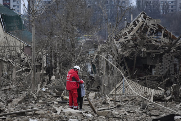 A medical worker comforts a woman after a Russian air attack in Zaporizhzhia, Ukraine on Friday. The latest barrage from Russian forces has hit targets all over Ukraine.