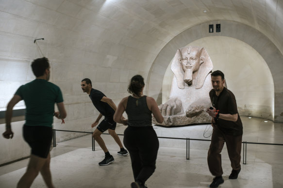 An exercise class, held before crowds arrive, in The Louvre Museum in Paris.
