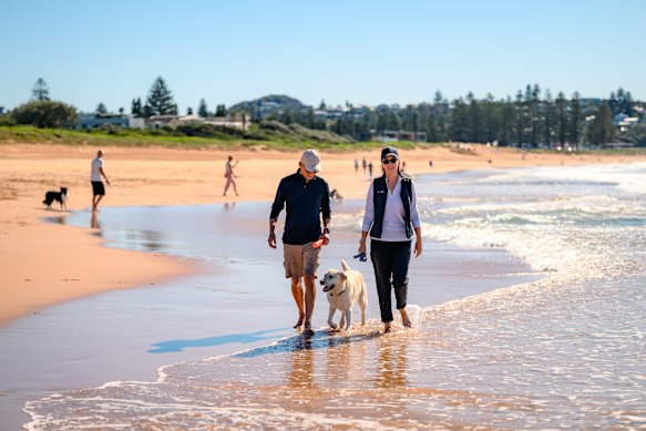 Julie Alexander-Bingham and her husband Warren Bingham with their Labrador at Mona Vale Beach.