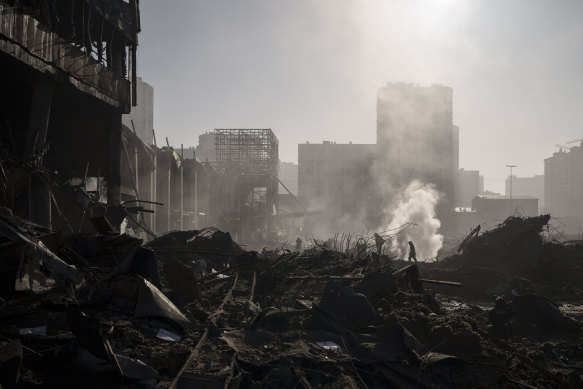Emergency services workers survey the wreckage after the shelling of a shopping centre in Kyiv.