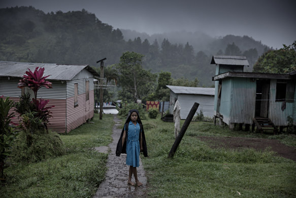 A young woman standing in the rain in the village of Naviavia, which has been bought from Fiji by Kiribati to ensure that Kiribati islanders have a place to go when the sea level overcomes their islands.