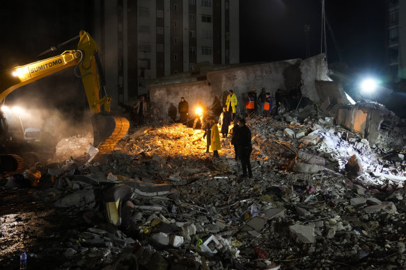 Teams search through the rubble in a destroyed building in Adana, Turkey.