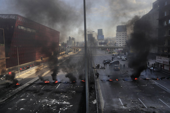 Black smoke rises from burning tires set by protesters to block a main highway north of Beirut.
