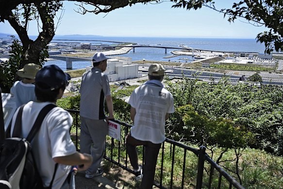 People who evacuated to the mountain of Hiyoriyama are looking towards the sea in Ishinoma of Northern Japan.