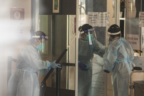 Cleaners wearing full PPE disinfect the Holiday Inn Hotel.