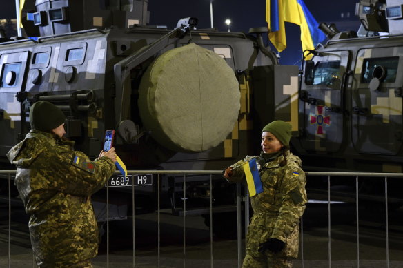 Two Ukrainian soldiers take a photo after the parade marking the Day of the Armed Forces of Ukraine in the centre of Kramatorsk, Ukraine.