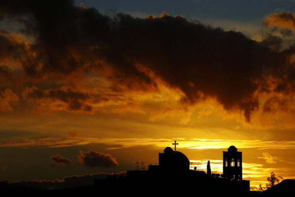 The sun sets behind a Christian Orthodox Church in Anthoupoli a suburb of the capital Nicosia, Cyprus.
