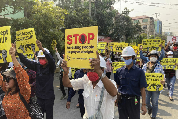 Anti-coup protesters display signs and shout slogans as they protest against the military coup in Mandalay, Myanmar, on Monday.