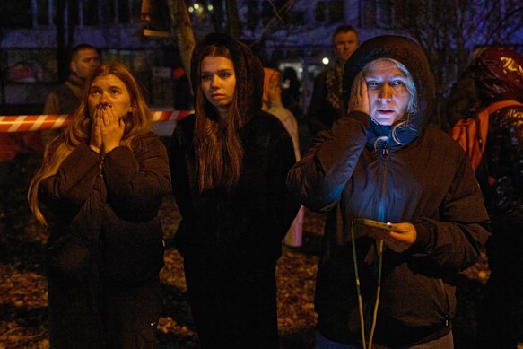Kyiv residents watch their home burning after a drone attack on Tuesday.
