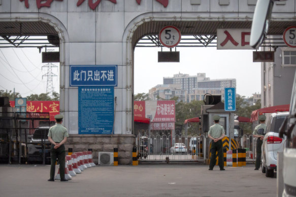 Chinese paramilitary police stand guard at barricaded entrances to the Xinfadi wholesale food market district in Beijing on Saturday.