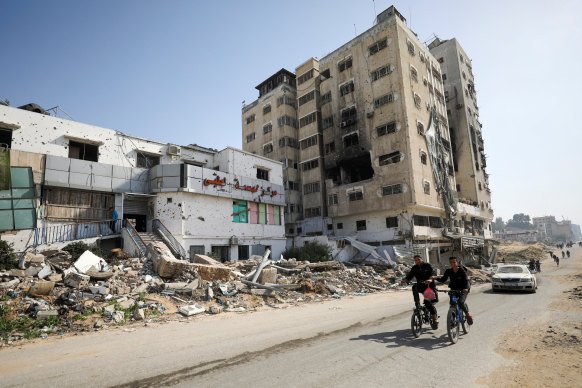 Palestinians ride bicycles past the Al Basma IVF Centre, Gaza’s largest fertility clinic.