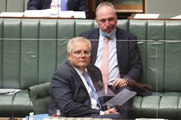 Mr Morrison and Mr Joyce, behind, in Parliament yesterday. 