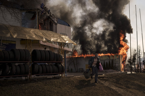 A man recovers items from a burning shop following a Russian attack in Kharkiv, Ukraine, on Friday.