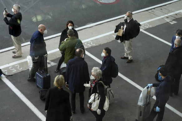 Members of the World Health Organization (WHO) team gather after arriving at the airport in Wuhan in central China's Hubei province on Thursday, January 14, 2021.