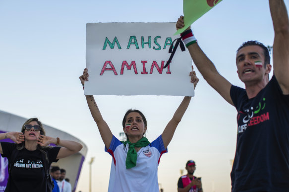 A woman holds up a sign reading Mahsa Amini, who died while in police custody in Iran at the age of 22, during a protest after the World Cup match between Wales and Iran in Qatar.