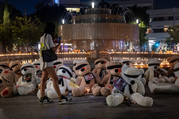 A woman walks past soft teddy bears with their eyes covered to highlight the young children and babies currently missing, believed to be being held hostage, by Hamas.