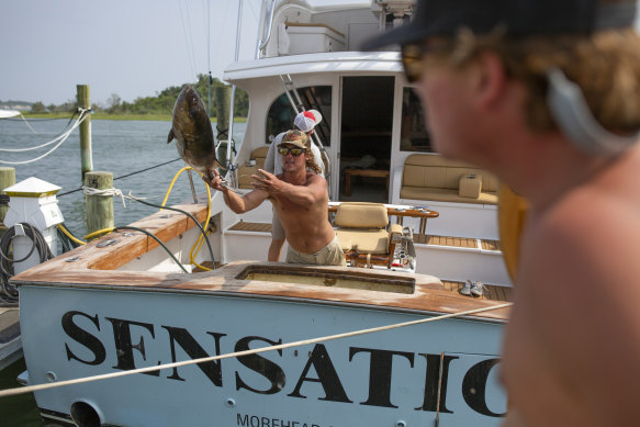 Darrin Cox, known as Scooter, unloading fish from the Sensation. On the last day of the tournament, he had a hunch Sensation would catch a marlin.