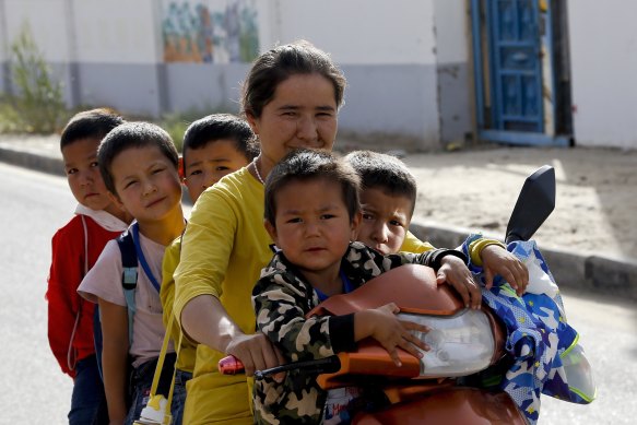 A Uighur woman and children sit on a motor-tricycle after school at the Unity New Village in Hotan, in western China's Xinjiang region. Birth rates in the mostly Uighur regions of Hotan and Kashgar have plunged by more than 60 per cent since 2015, government statistics show. 