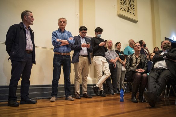 Members of the public line up to ask a question.