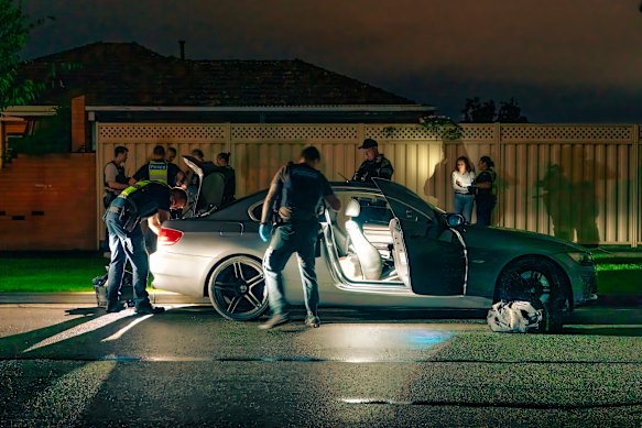 Officers search the stolen BMW and question its occupants. 