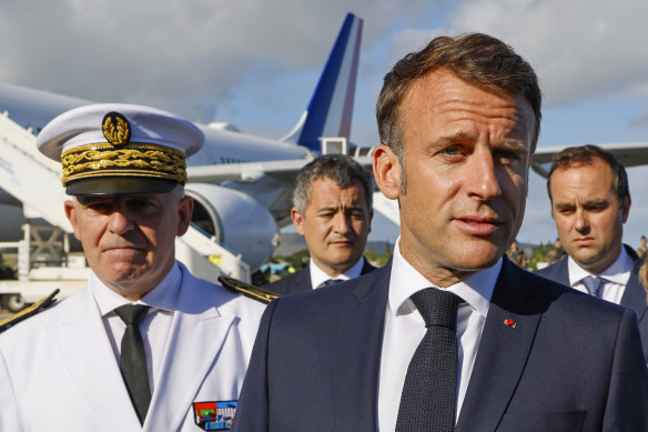 French President Emmanuel Macron surrounded by a “clone-like trio of 40-something technocrats” after stepping off his plane in New Caledonia on Thursday.