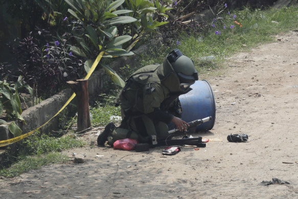 A member of the police bomb disposal squad inspects a suspicious package found inside a garbage, that they later destroyed, in Bekasi on the outskirts of Jakarta, Indonesia, on Monday.