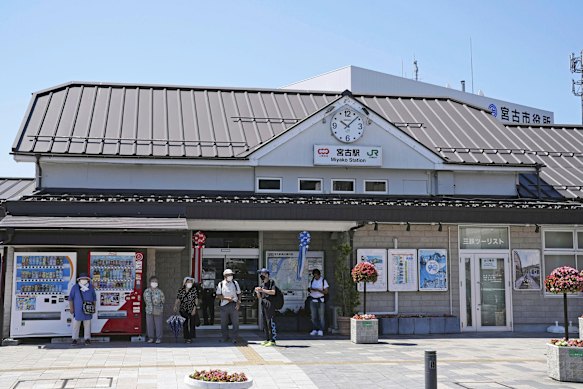 Passengers are standing in front of a station in Miyako, Northern Japan after the train services are stopped after the earthquake.