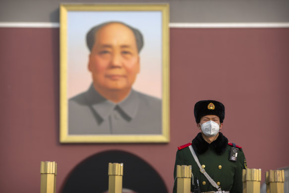 A paramilitary policeman stands guard in front of a giant portrait of late Chinese leader Mao Zedong in Beijing.