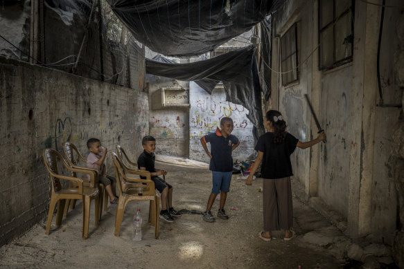Palestinian children play under tarpaulins hung up to block the view of Israeli drones in the Nur Shams refugee camp, Tulkarm, West Bank.