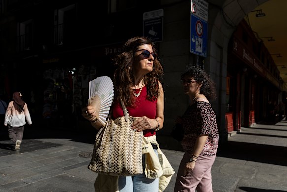 A woman uses a fan at Plaza Mayor in Madrid. 
