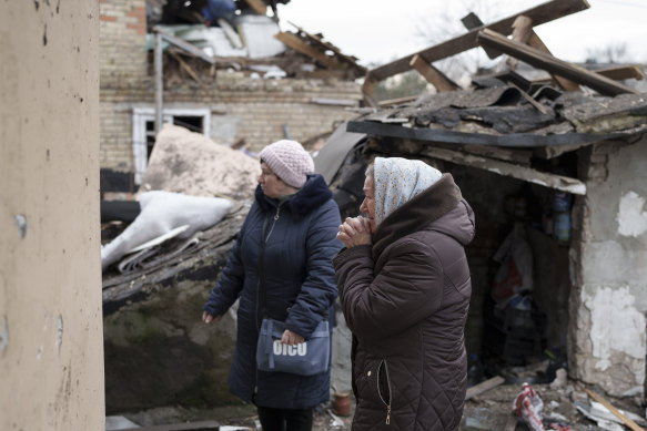 Anhelina, right, watches as emergency workers remove debris of her house, destroyed following a Russian missile attack in Kyiv, Ukraine, on December 29.