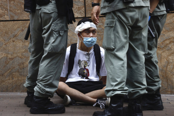 Riot police guard a protester as a second reading of a controversial national anthem law takes place in Hong Kong on Wednesday.