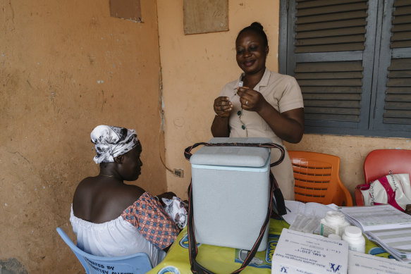 Deborah Sebi (R), prepares a vaccination for Rebecca Bamembaye’s 3-month-old, Doris, at the Teshie mobile clinic. 