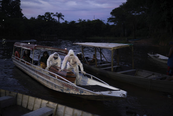 Funeral workers transport an 86-year-old woman's coffin by boat after she died of suspected COVID-19 near Manaus, Brazil.