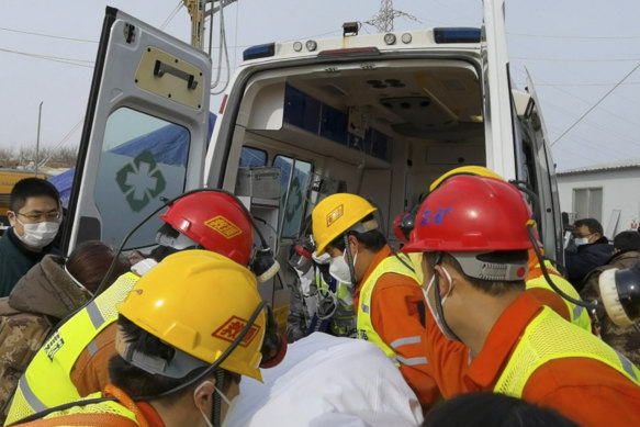 Rescuers carry a miner who was trapped in a gold mine. 