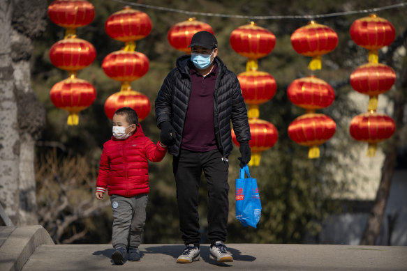 A man and child walk past lanterns at a public park in Beijing. While Beijing ended its controversial one-child policy in 2017, it had not yet published new family size limits.