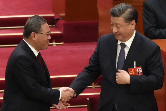 Newly elected Premier Li Qiang, left, shakes hands with Chinese President Xi Jinping during a session of China’s National People’s Congress.